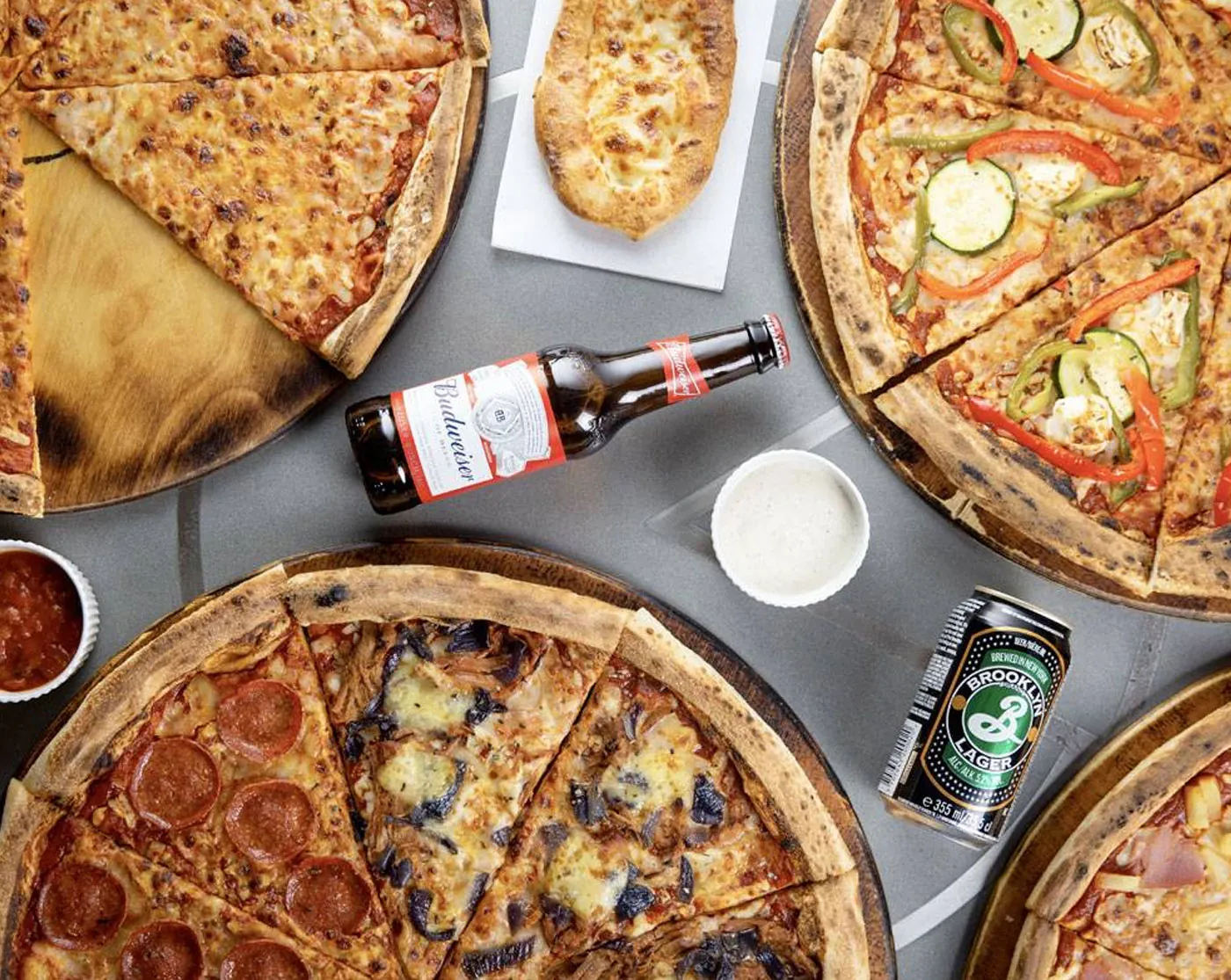 Pizzas and drinks laid out on a table